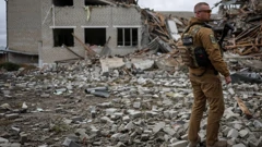 Vojnik pored pogođene škole u gradu Verbivki u harkivskoj regiji